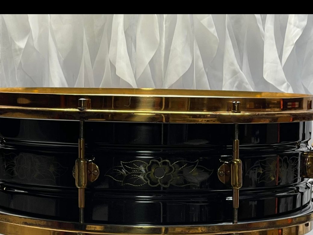 Ludwig snare drum with black lacquered shell, gold floral engraving, and brass hoops